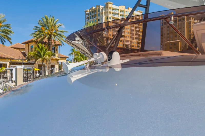Slide: The Image of 2022 Prestige 520 yacht with sleek design, docked near palm trees and luxury buildings. - 16