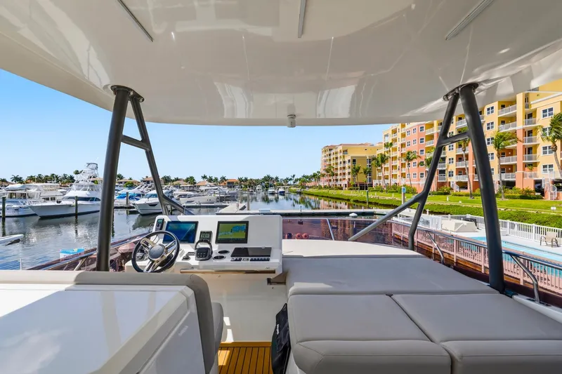 Slide: The Image of Flybridge view of 2022 Prestige 520 yacht docked at a marina with waterfront buildings. - 20