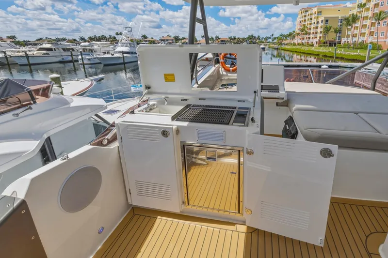 Slide: The Image of Luxury yacht Prestige 520, 2022 model, featuring an outdoor kitchen and scenic marina view. - 26