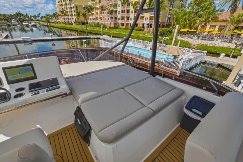 Slide: The Image of Flybridge of 2022 Prestige 520 yacht with seating, control panel, and marina view. - 27