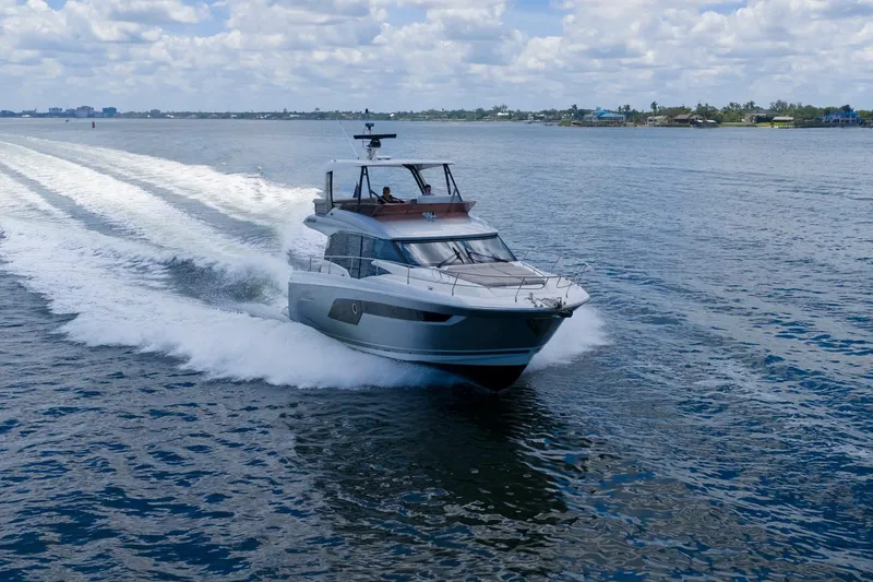 Slide: The Image of Luxury 2022 Prestige 520 yacht cruising on open water under a cloudy sky. - 7