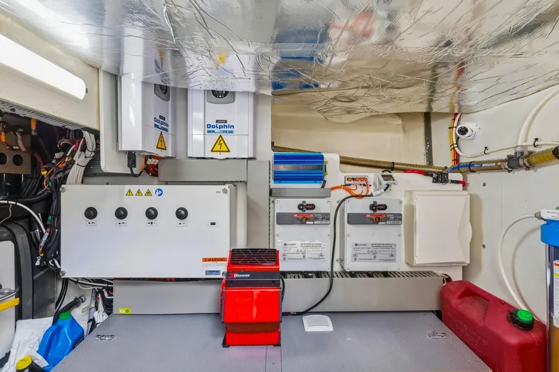 Slide: The Image of Engine room of a 2022 Prestige 520 yacht, featuring electrical panels and equipment. - 76