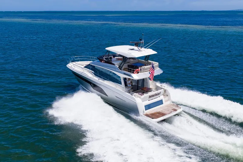 Slide: The Image of Luxury 2022 Prestige 520 yacht cruising on open blue ocean waters. - 8