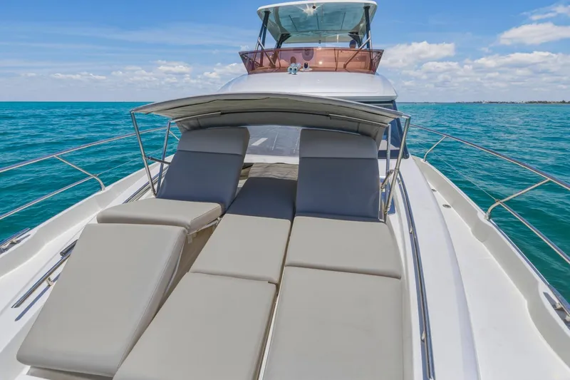 Slide: The Image of Luxury 2022 Prestige 520 yacht with sun loungers on open sea. - 80
