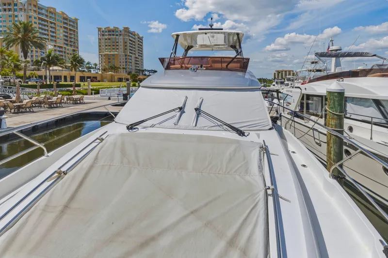 Slide: The Image of Luxury 2022 Prestige 520 yacht docked at marina with modern buildings in background. - 84