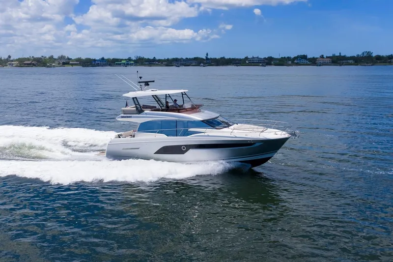 Slide: The Image of 2022 Prestige 520 yacht cruising on open water under a clear blue sky. - 87