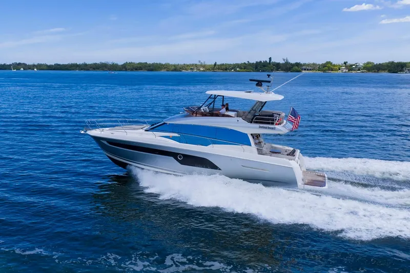 Slide: The Image of 2022 Prestige 520 yacht cruising on blue waters under a clear sky. - 89