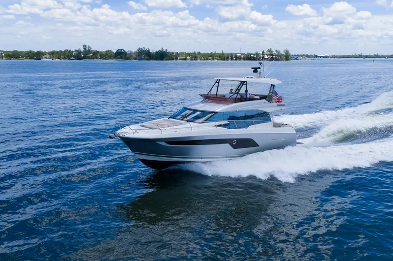 Slide: The Image of Luxury 2022 Prestige 520 yacht cruising on open water under a clear sky. - 91