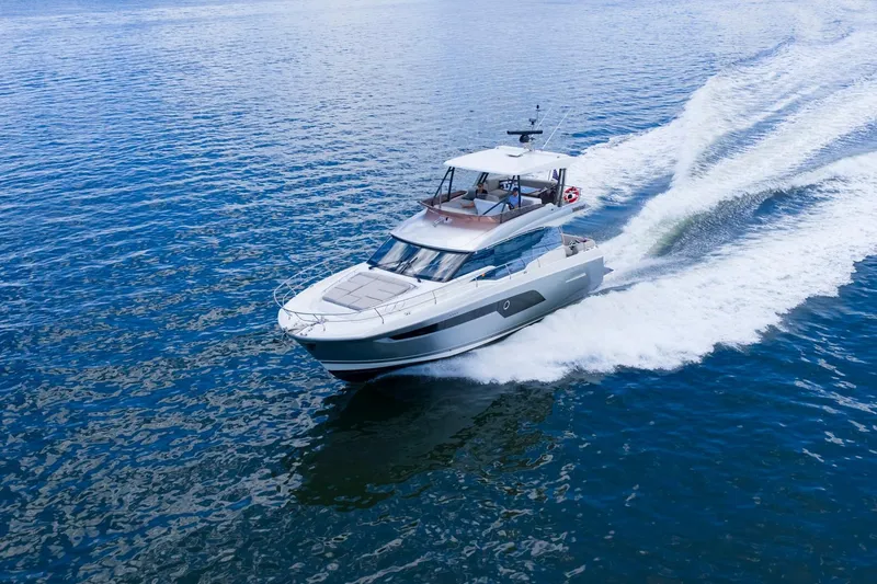 Slide: The Image of 2022 Prestige 520 yacht cruising on open water, creating a dynamic wake. - 92