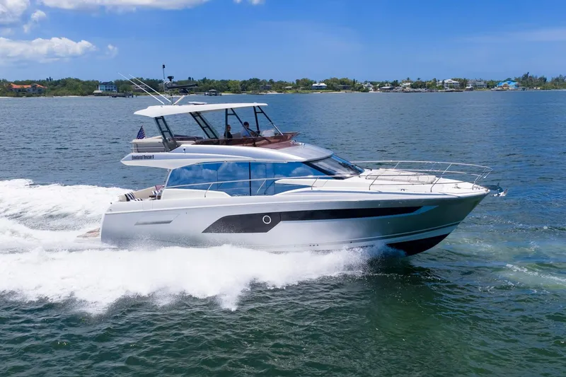 Slide: The Image of 2022 Prestige 520 yacht cruising on open water under clear blue skies. - 93