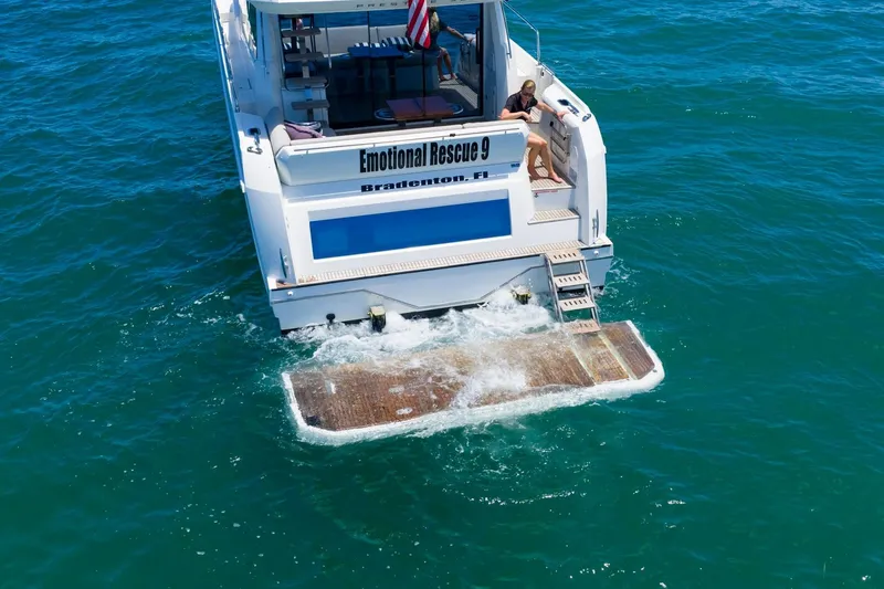 Slide: The Image of Prestige 520 yacht on water, rear view, with swim platform and person onboard. - 98