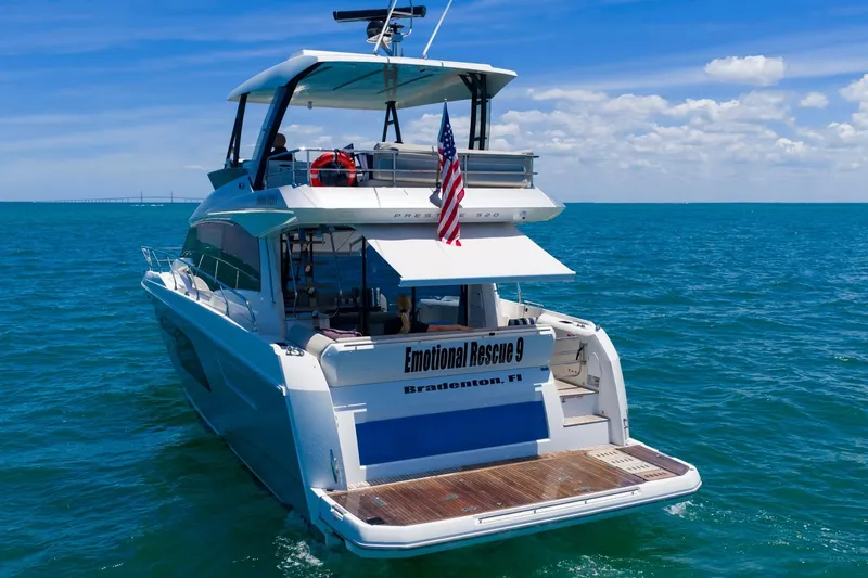 Slide: The Image of Luxury 2022 Prestige 520 yacht cruising in open sea with American flag. - 99