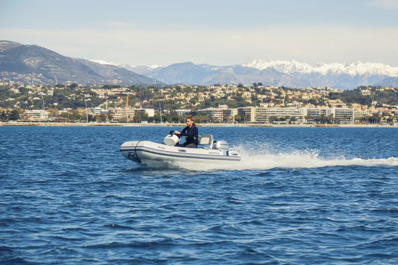 Slide: The Image of 2026 Highfield Classic 340 boat cruising on scenic coastal waters with mountains in the background. - 2