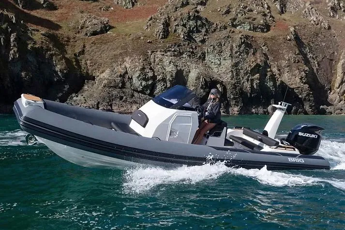 The Image of Manufacturer Provided Image: 2026 Brig Eagle 8 boat cruising near rocky cliffs with Suzuki engine. - 0