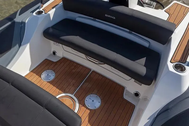 Slide: The Image of Manufacturer Provided Image: 2026 Brig Eagle 8 boat interior with sleek black seating and wooden flooring. - 6