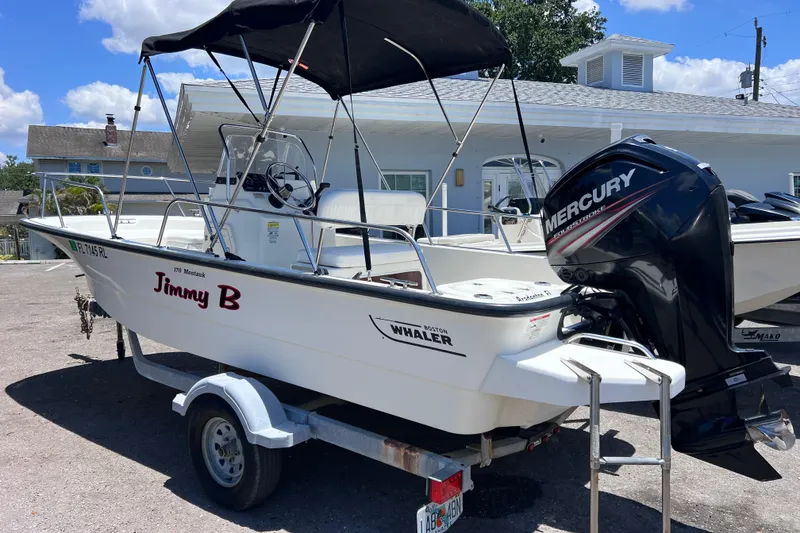 The Image of 2017 Boston Whaler 170 Montauk boat with Mercury engine on trailer, parked outdoors. - 0