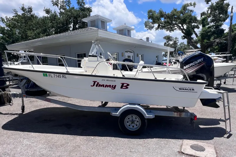 Slide: The Image of 2017 Boston Whaler 170 Montauk boat on trailer, labeled "Jimmy B," with Mercury engine. - 1