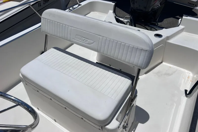 Slide: The Image of 2017 Boston Whaler 170 Montauk boat interior with white seating and steering wheel. - 16