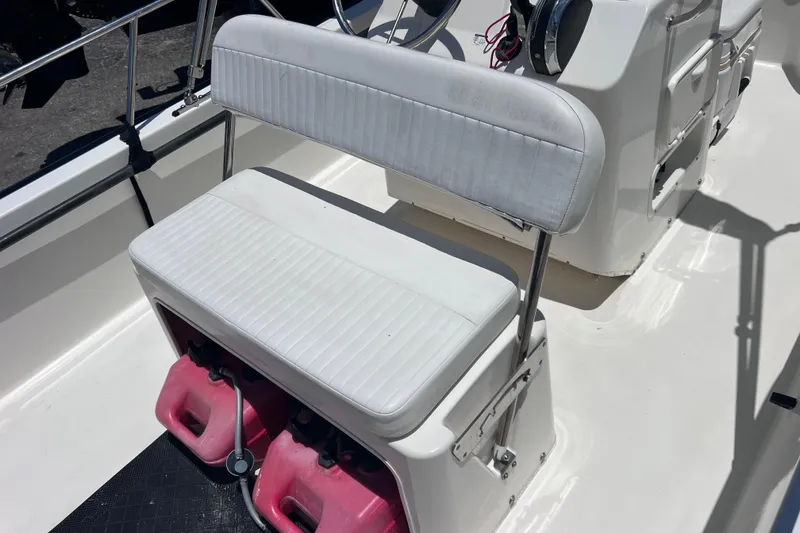 Slide: The Image of 2017 Boston Whaler 170 Montauk boat interior with white seating and red fuel containers. - 17