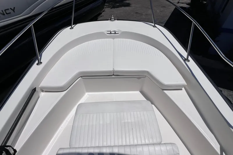 Slide: The Image of 2017 Boston Whaler 170 Montauk boat interior with white seating and stainless steel railings. - 20