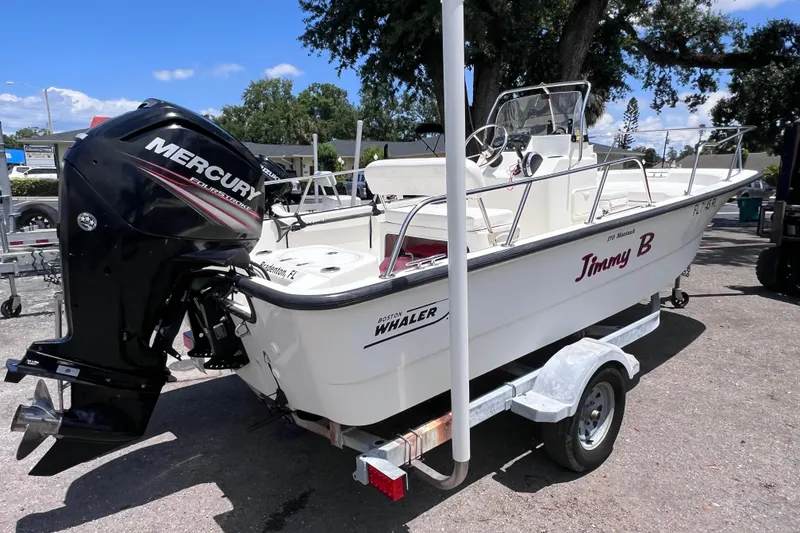 Slide: The Image of 2017 Boston Whaler 170 Montauk boat with Mercury engine on trailer, parked outdoors. - 4