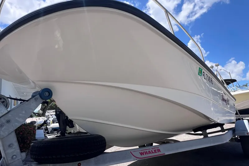 Slide: The Image of 2017 Boston Whaler 170 Montauk boat on trailer under blue sky. - 8