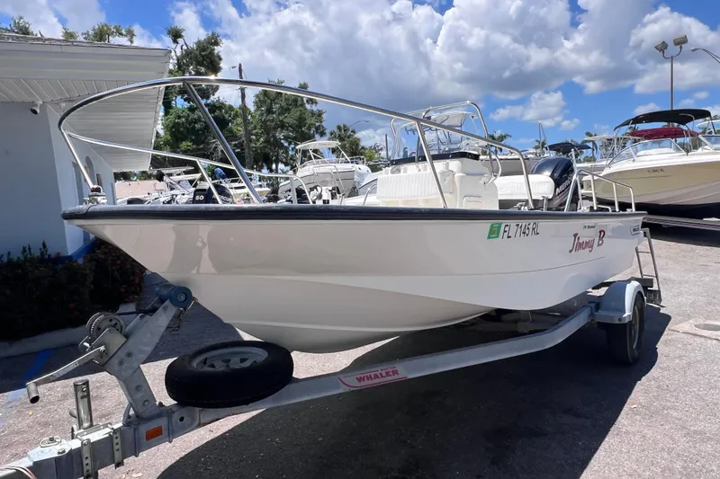 Slide: The Image of 2017 Boston Whaler 170 Montauk boat on trailer under a sunny sky. - 9
