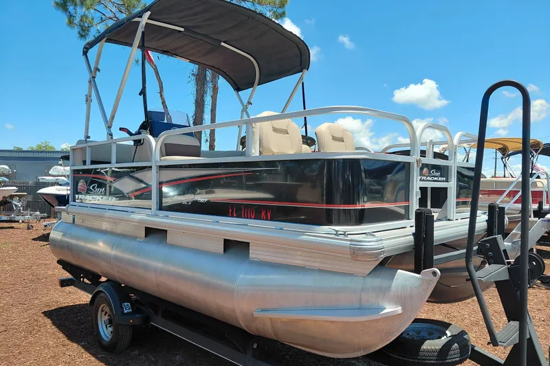 The Image of 2019 Sun Tracker Bass Buggy 16 DLX pontoon boat on trailer, sunny day. - 1