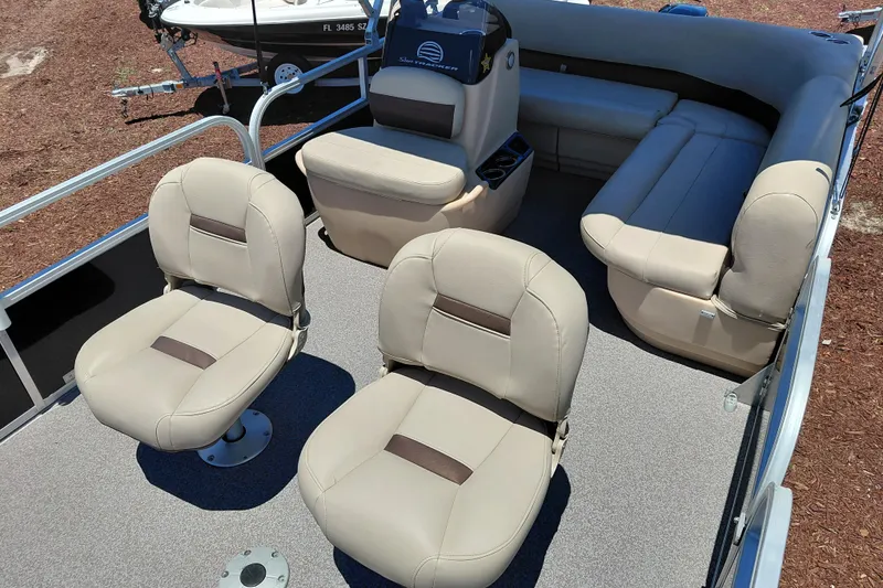 Slide: The Image of 2019 Sun Tracker Bass Buggy 16 DLX pontoon boat interior with beige seating and helm. - 15