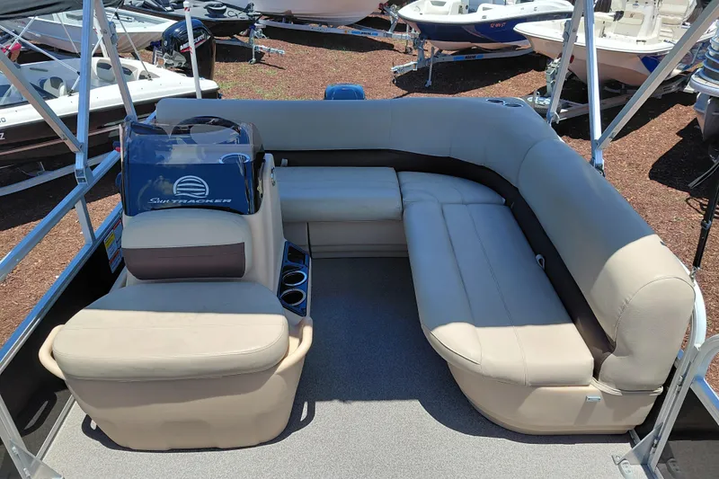 Slide: The Image of 2019 Sun Tracker Bass Buggy 16 DLX pontoon boat with beige seating and steering console. - 16
