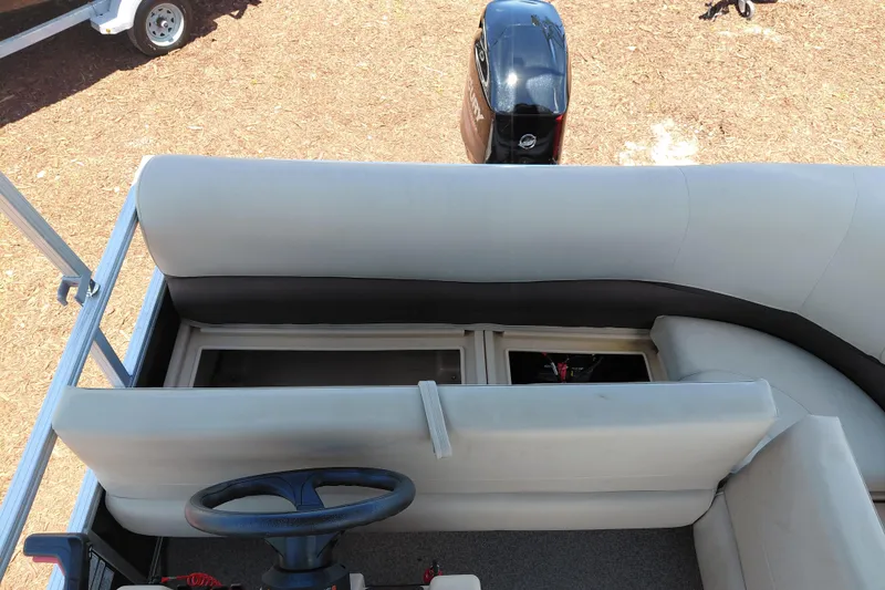 Slide: The Image of 2019 Sun Tracker Bass Buggy 16 DLX pontoon boat interior with seating and steering wheel. - 24