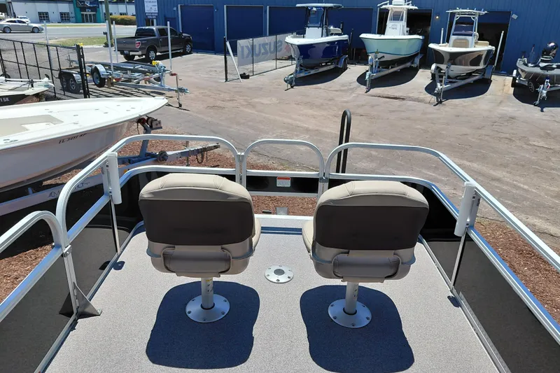 Slide: The Image of 2019 Sun Tracker Bass Buggy 16 DLX pontoon boat with dual seats, parked at a dealership. - 28
