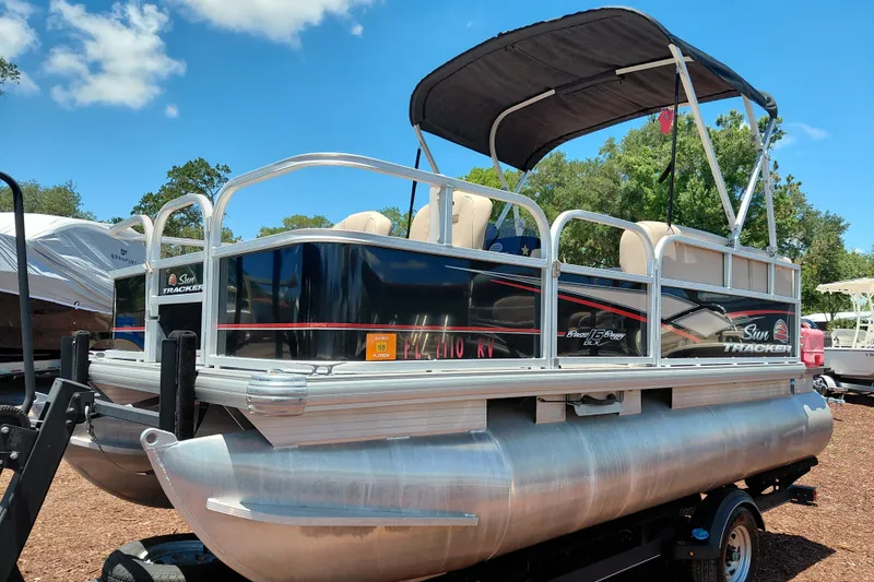 Slide: The Image of 2019 Sun Tracker Bass Buggy 16 DLX pontoon boat on trailer under blue sky. - 3