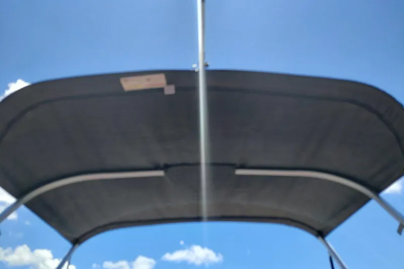 Slide: The Image of 2019 Sun Tracker Bass Buggy 16 DLX canopy under clear blue sky. - 32