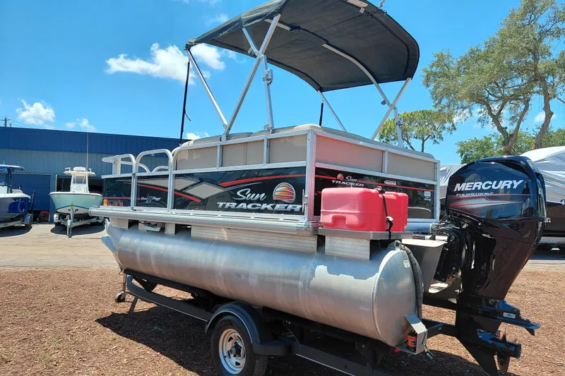 Slide: The Image of 2019 Sun Tracker Bass Buggy 16 DLX pontoon boat with Mercury outboard motor, parked outdoors. - 5