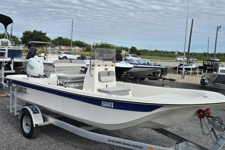 Slide: The Image of 2025 Carolina Skiff E18 JVX CC boat on trailer, displayed outdoors. - 10