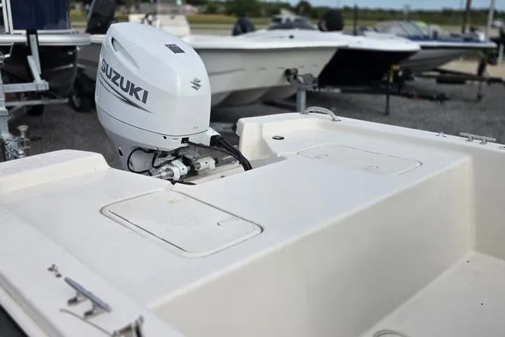 Slide: The Image of 2025 Carolina Skiff E18 JVX CC boat with Suzuki outboard motor, parked on a trailer. - 15