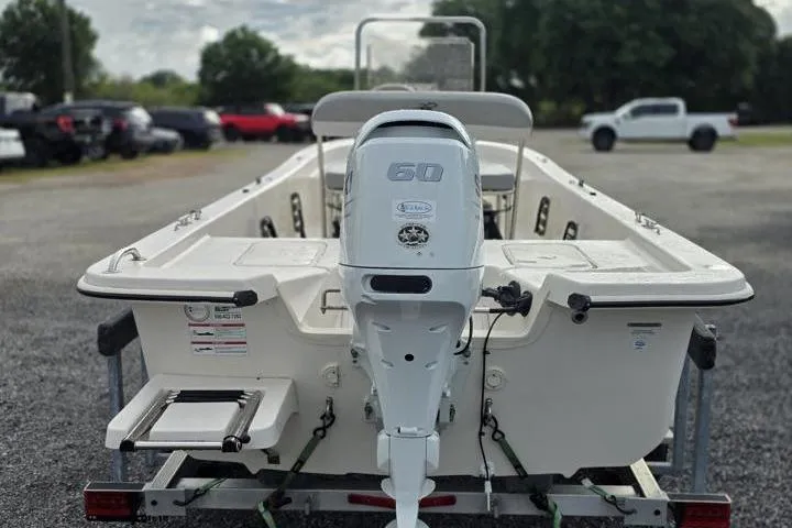 Slide: The Image of 2025 Carolina Skiff E18 JVX CC boat with 60 HP engine, parked outdoors. - 7