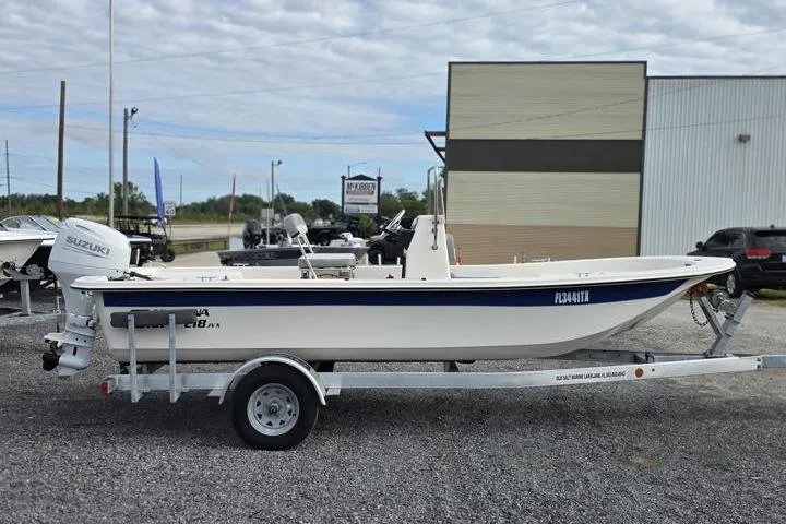 Slide: The Image of 2025 Carolina Skiff E18 JVX CC boat on trailer, side view, outdoors. - 9