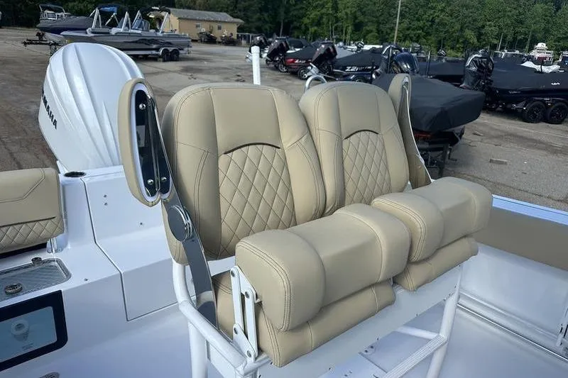 Slide: The Image of 2026 Sportsman Heritage 231 Center Console boat with beige cushioned seating. - 13
