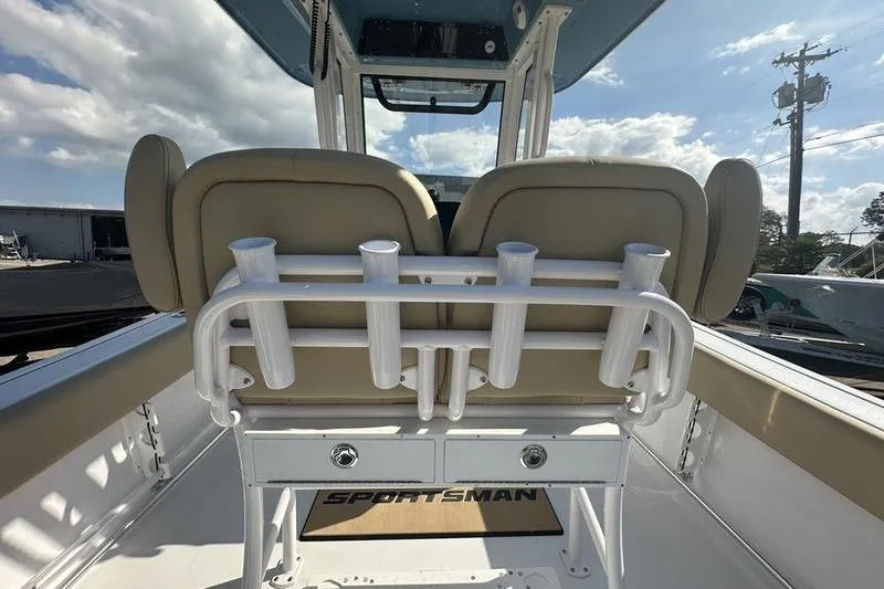 Slide: The Image of 2026 Sportsman Heritage 231 Center Console boat interior with rod holders and cushioned seating. - 14