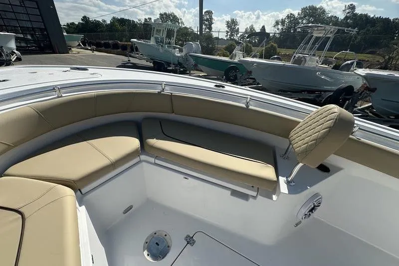 Slide: The Image of 2026 Sportsman Heritage 231 Center Console boat with beige seating in a marina. - 22
