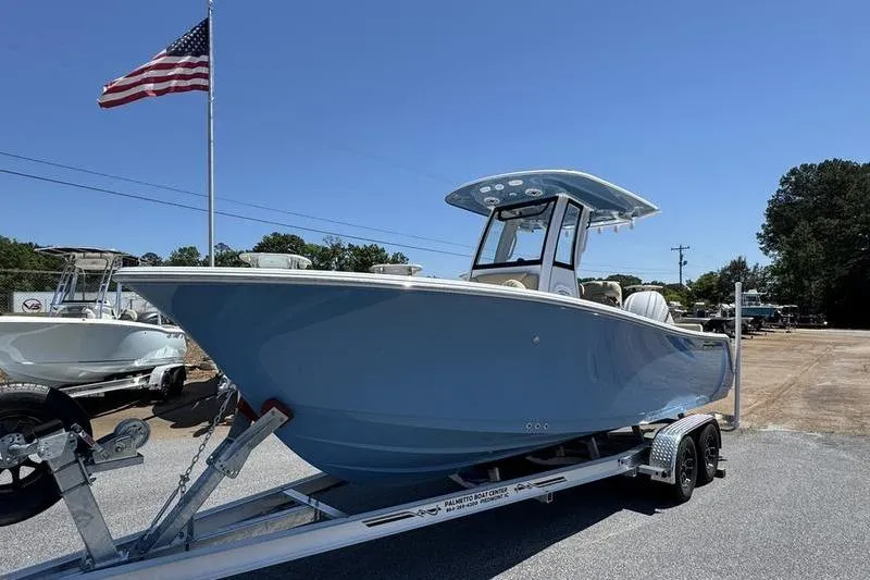 Slide: The Image of 2026 Sportsman Heritage 231 Center Console boat on trailer, under clear blue sky. - 27