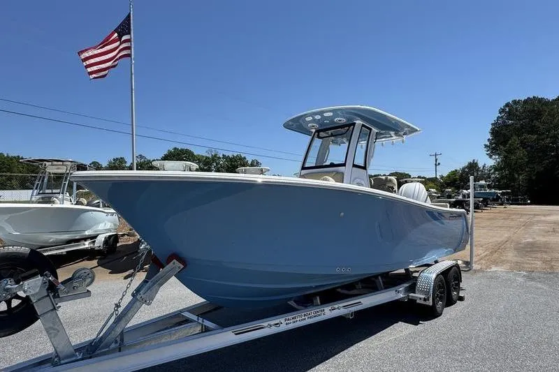 Slide: The Image of 2026 Sportsman Heritage 231 Center Console boat on trailer, with American flag in background. - 3