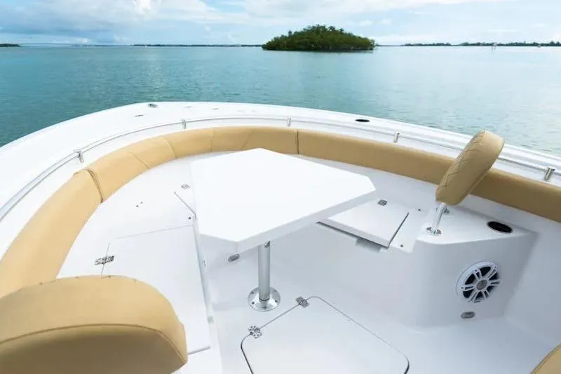 Slide: The Image of 2026 Sportsman Heritage 231 Center Console boat with seating and table on calm water. - 31