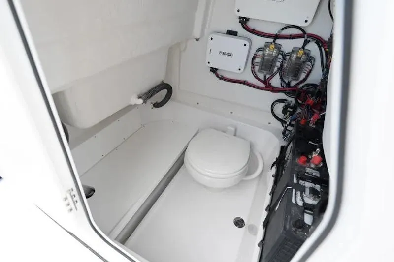 Slide: The Image of Interior of 2026 Sportsman Heritage 231 Center Console boat, featuring a compact marine toilet. - 32