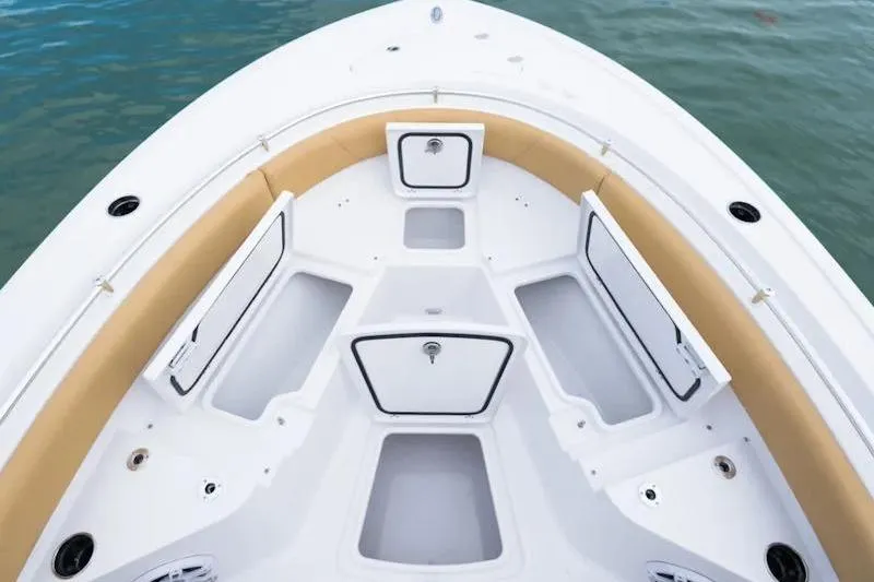 Slide: The Image of 2026 Sportsman Heritage 231 Center Console boat interior with storage compartments and cushioned seating. - 34