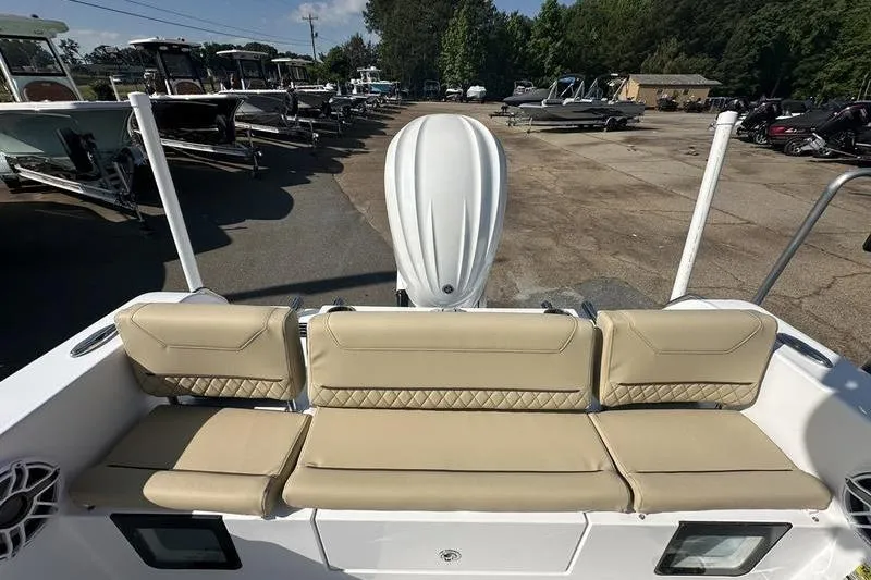 Slide: The Image of 2026 Sportsman Heritage 231 Center Console boat with beige seating, parked outdoors. - 5