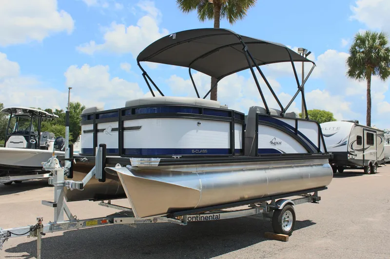 The Image of 2026 Qwest Lanai 816 pontoon boat on trailer, under sunny skies with palm trees. - 0