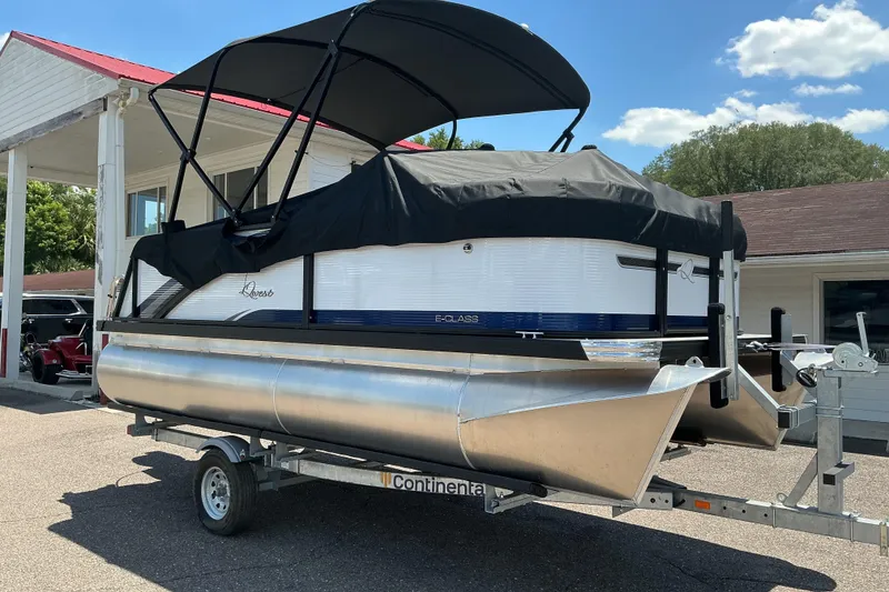 Slide: The Image of 2026 Qwest Lanai 816 pontoon boat on trailer, covered and parked outdoors. - 21
